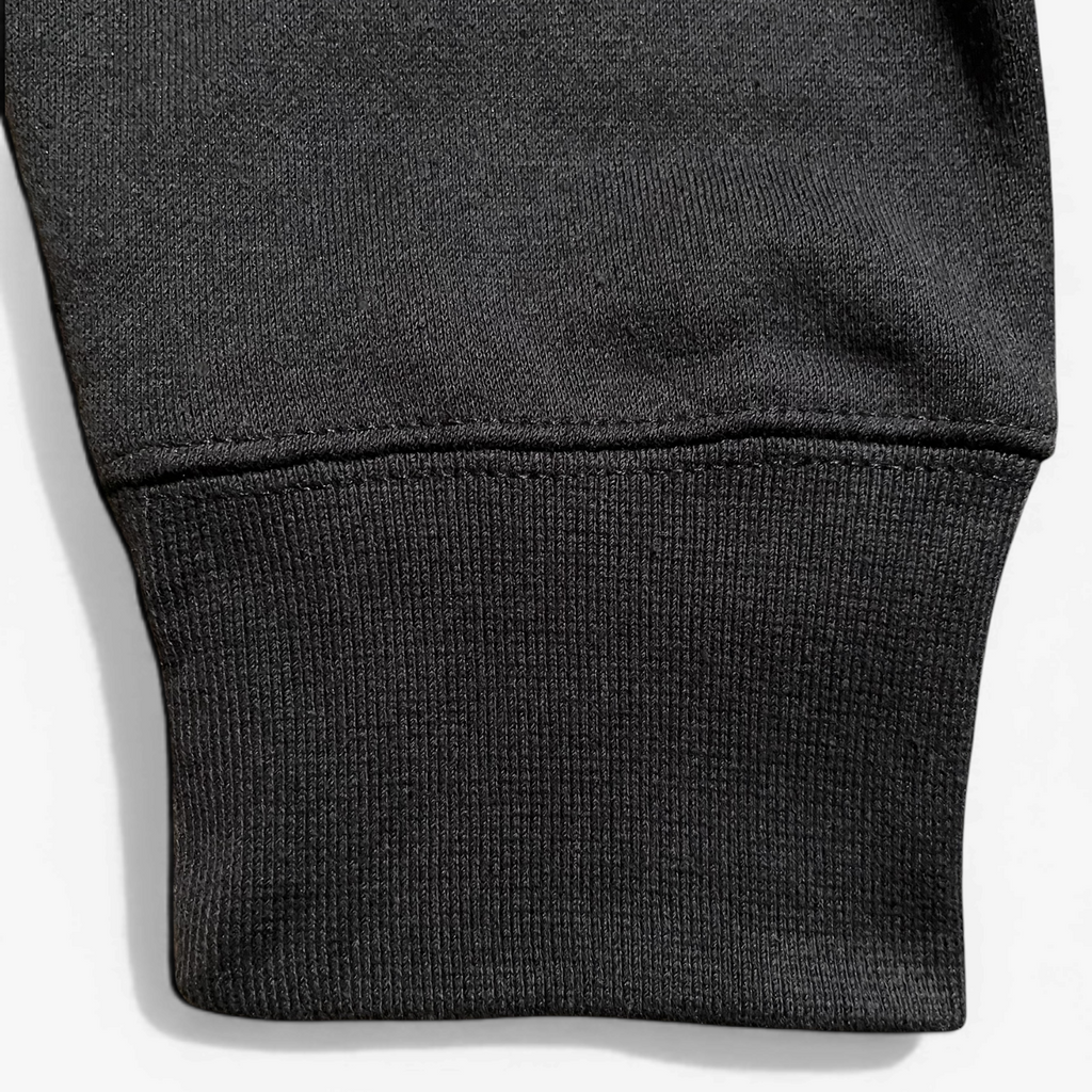 Close-up of a black sleeve with a textured top on a white background